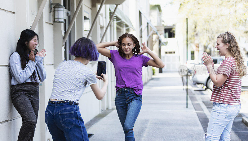 少女用智能手机拍摄朋友