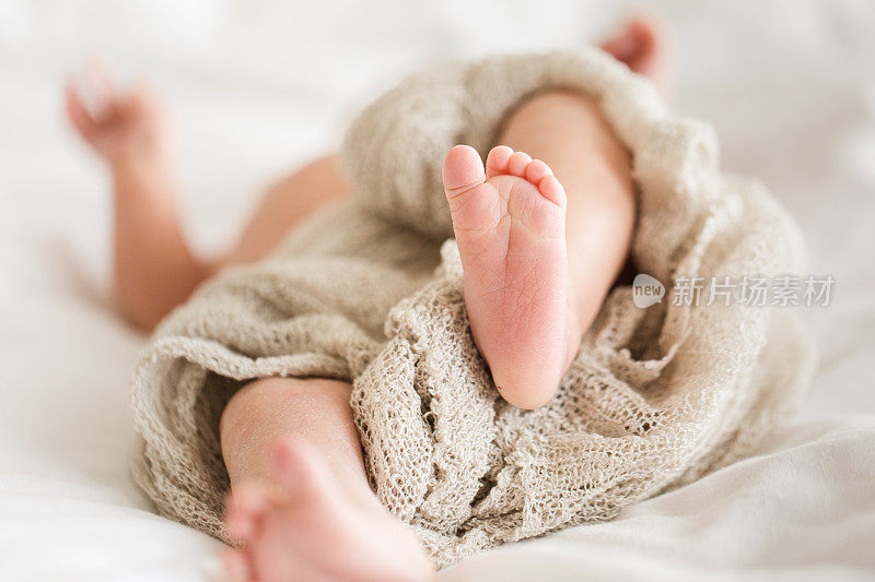新生儿的脚和腿与白色的背景