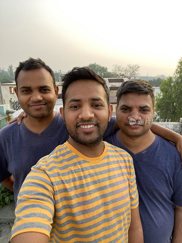 印度教徒在屋顶上庆祝胡里节的颜色和爱，兄弟和姐夫一家人在清理油漆争斗后自拍