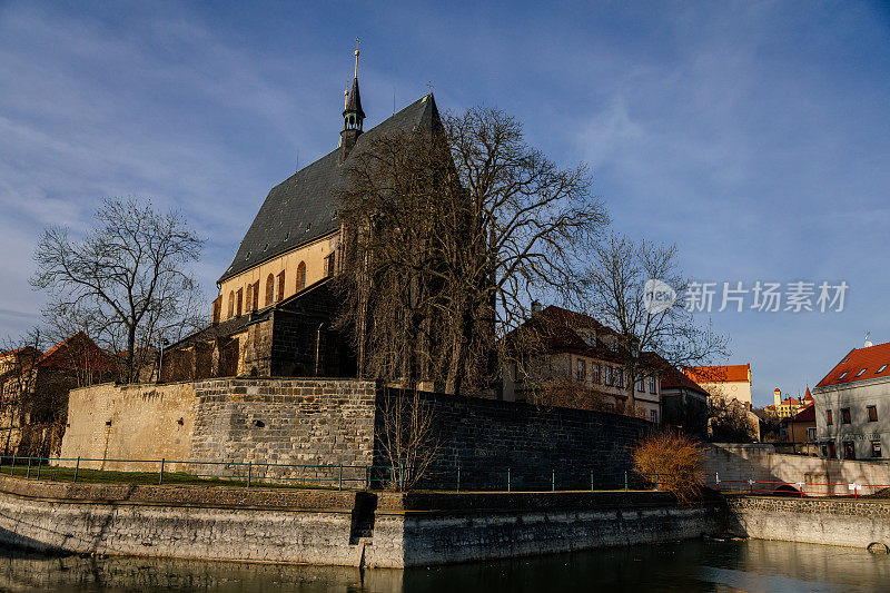 2020年12月27日，捷克共和国，波西米亚中部，中世纪小镇Slany中心，城市防御工事和带有钟楼的哥特式教堂附近的池塘
