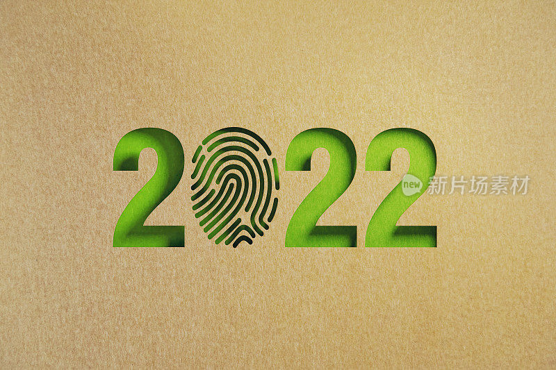 可持续发展的概念-剪出指纹形状的再生纸形成2022在绿色背景