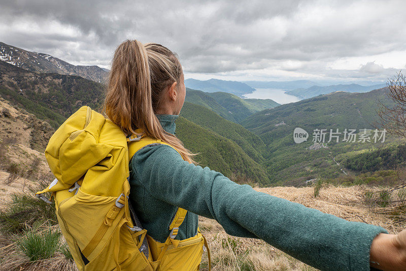 一个徒步旅行者双臂伸开站在山顶上