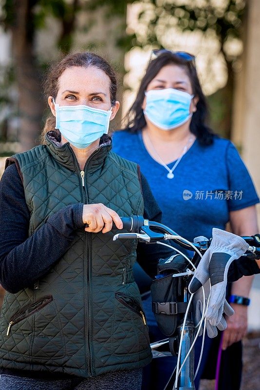 女邻居戴着防护口罩，因为流行病拿着自行车