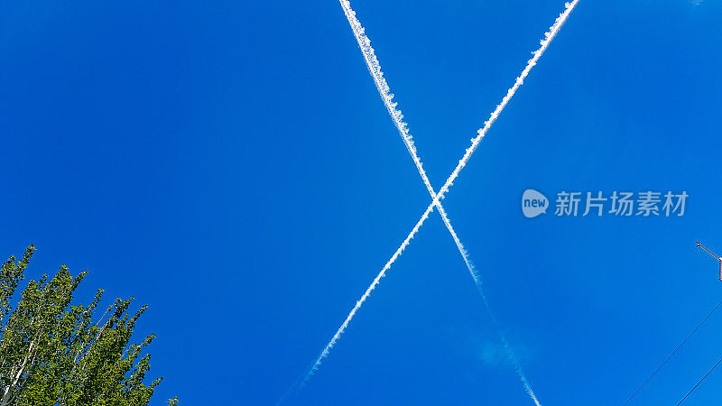 蓝色天空中飞过的白色飞机线
