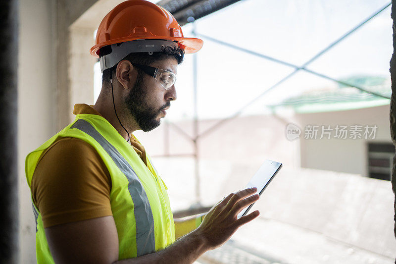 年轻的工程师在建筑工地使用数码平板电脑