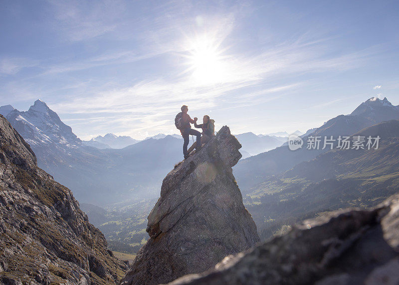 登山队员在阳光灿烂的岩峰上击掌