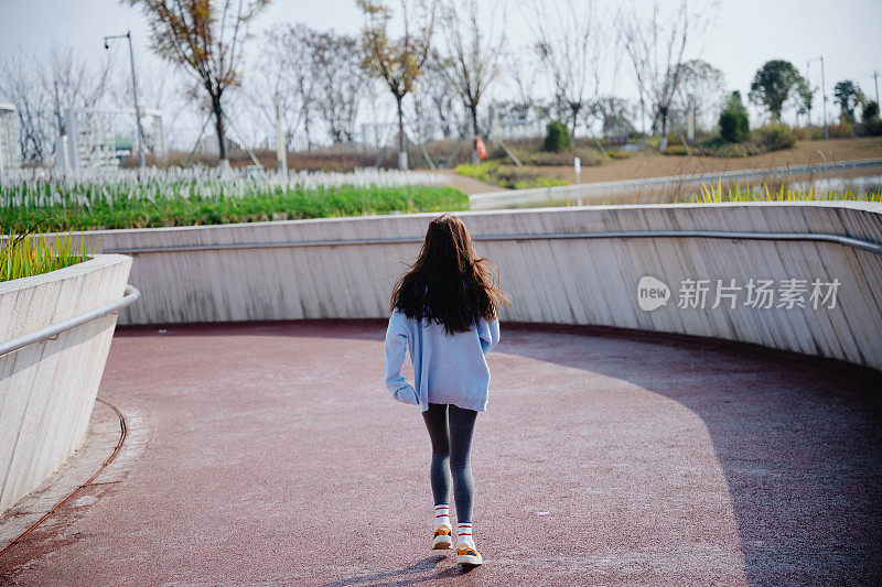 亚洲美丽的女孩快乐地奔跑在一个阳光明媚的日子