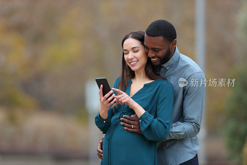 怀孕的妻子和她的丈夫在看智能手机