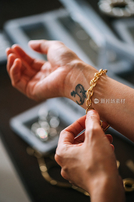 一名亚洲女性的手展示着金手镯等奢侈饰品
