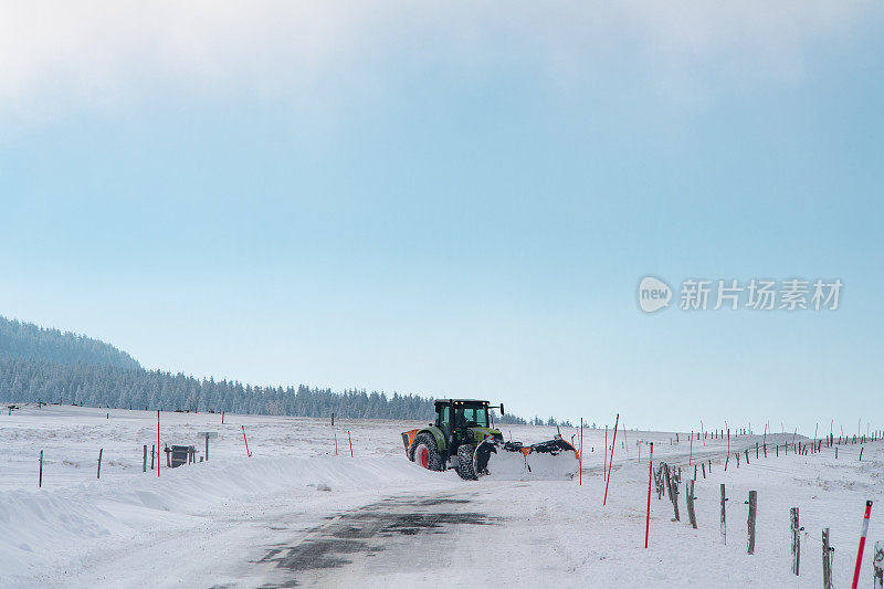 一辆扫雪机在雪路上滑行