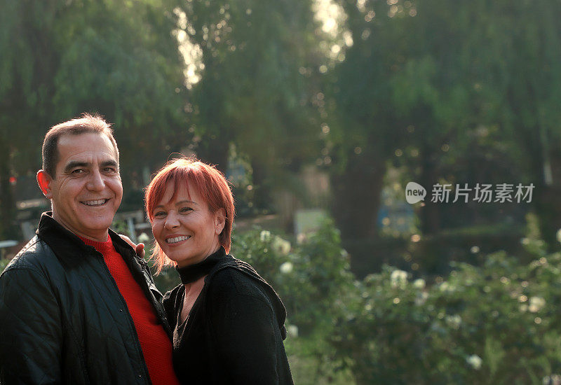 户外肖像中年已婚高加索夫妇在阳光明媚的绿色花园