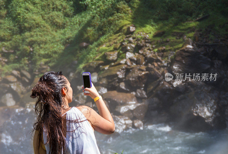 美丽和成功的年轻女子在一个自然公园网上购物