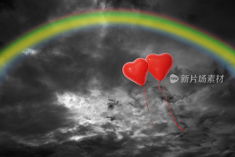 两个红色的心形气球在暴风雨后带着彩虹漂浮在云上