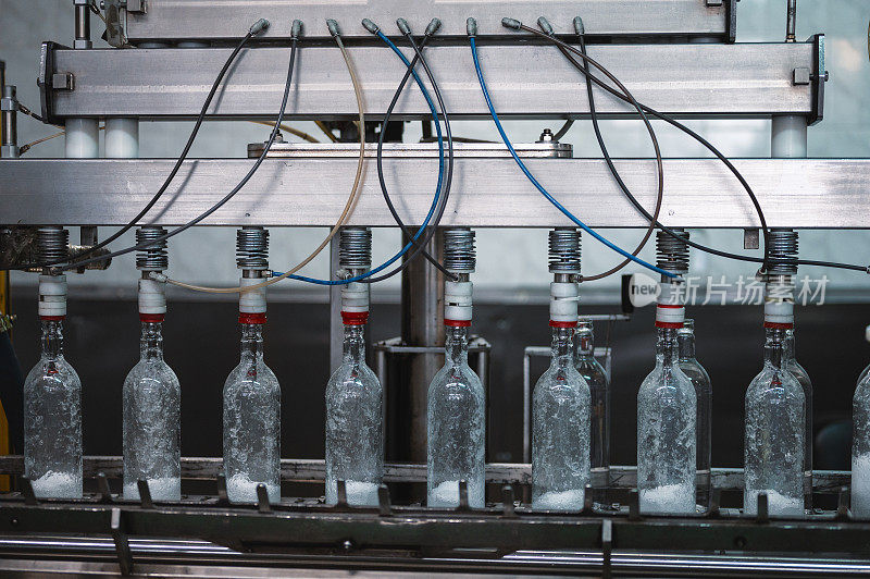 在生产线上用伏特加酒灌装玻璃瓶