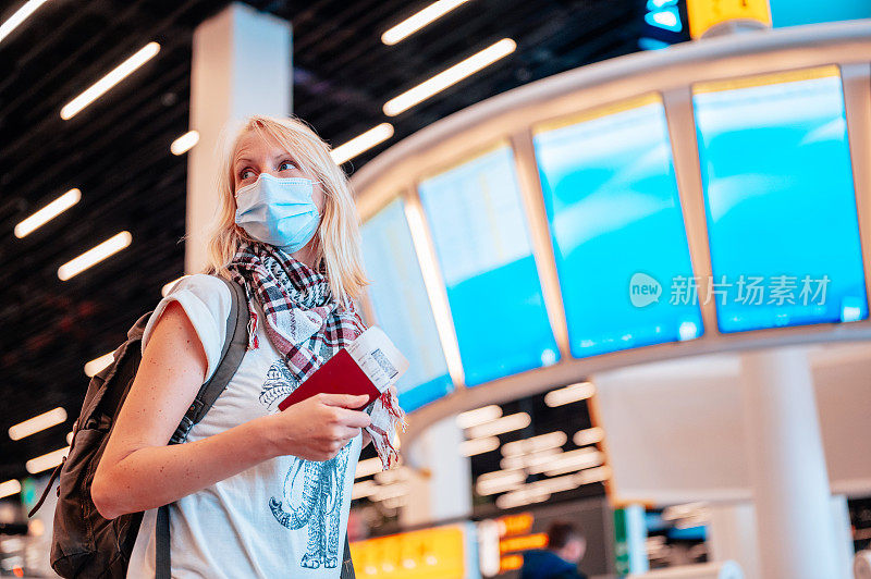 一位女士在机场拿着护照和登机牌