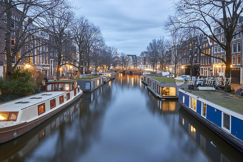 黄昏时分，阿姆斯特丹的城市运河上有一群船屋