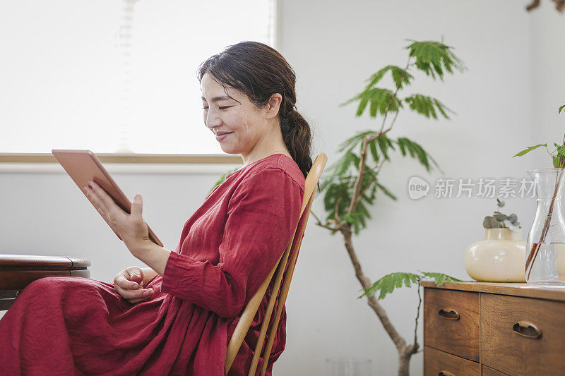 女人在客厅使用电子平板电脑。