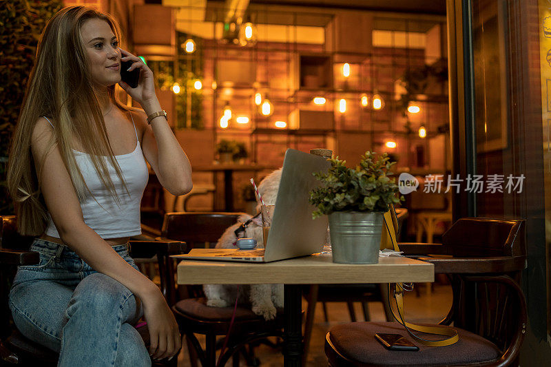 一名女性使用手机的照片，在Café