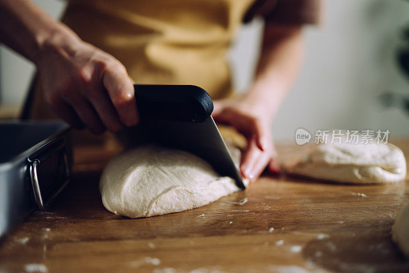 女面包师用刮面机切面团