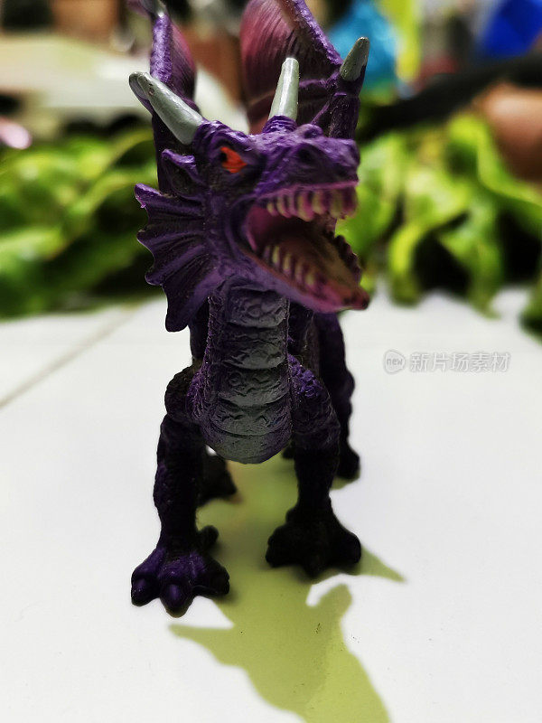 龙形人物玩具是紫色的，有两个白色的角