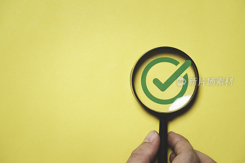 放大镜内的绿色正确或勾标记用于重点批准文件和项目概念。