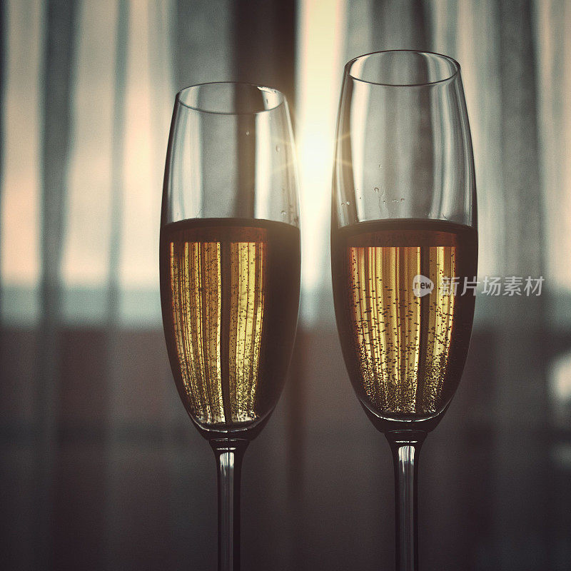 漂亮的镜头的两个玻璃杯香槟模糊的窗户和窗帘背景