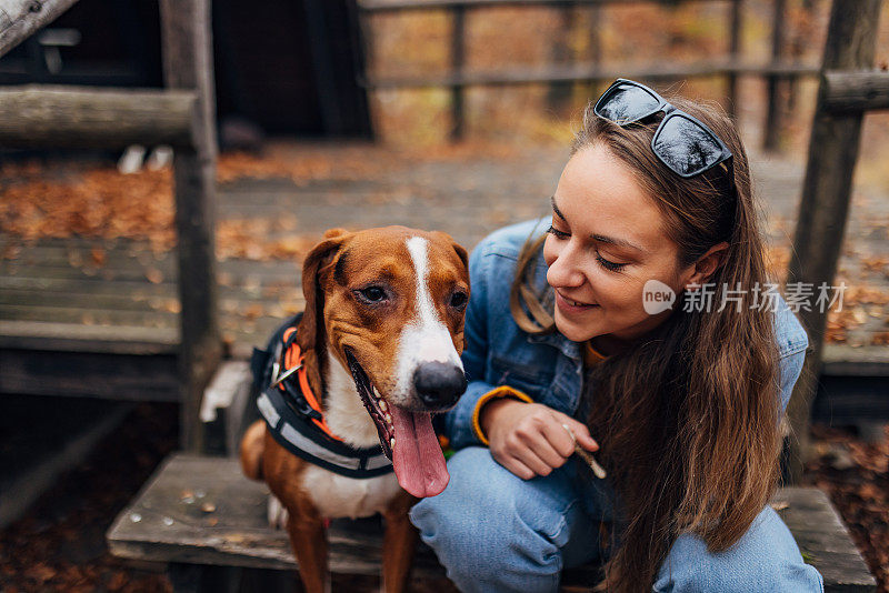 快乐的女人和她的猎犬在户外享受秋日