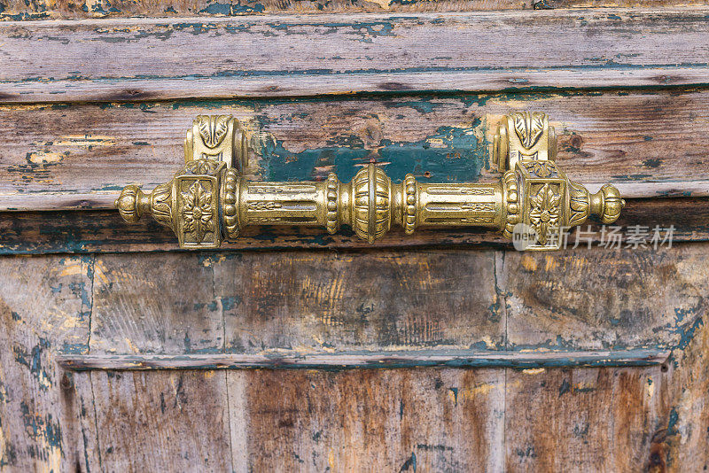 一扇旧门上的古董黄铜门把手，油漆已经脱落