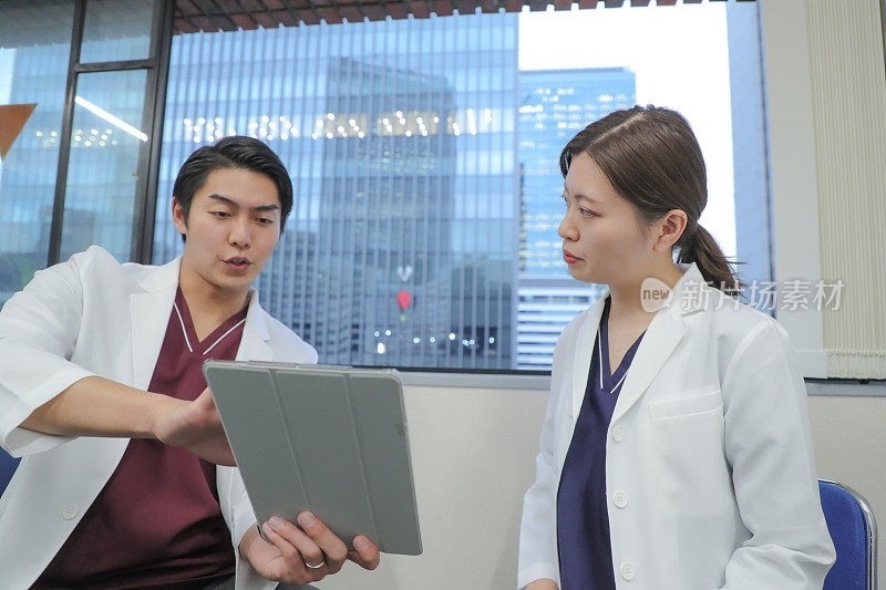 年轻的亚洲医疗专业人士讨论医疗信息