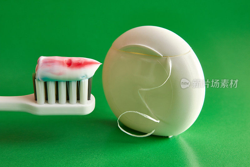 绿色背景上的牙刷、牙膏和牙线。牙科保健。口腔卫生。