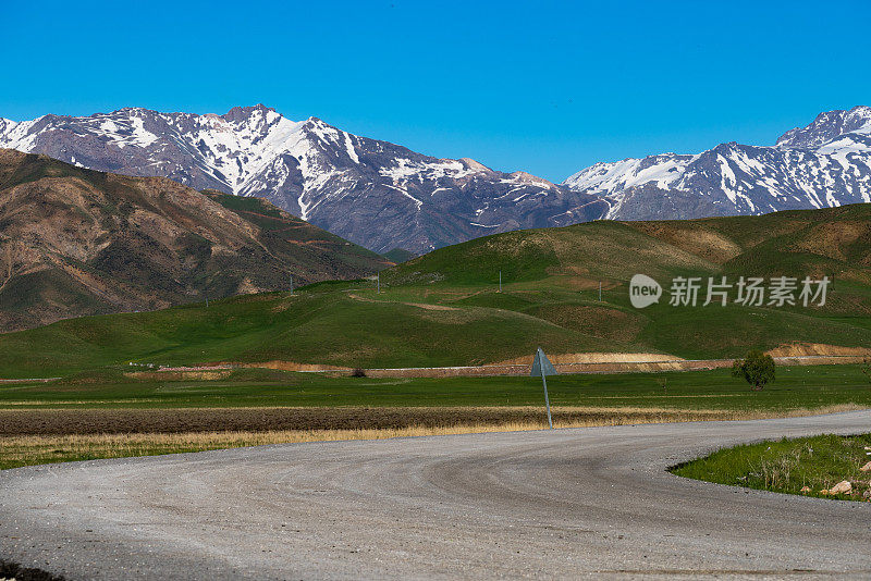 蜿蜒的柏油路蜿蜒向雪山