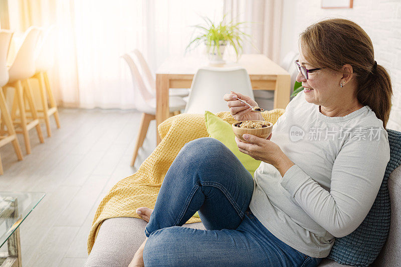 放松的女人在家里享用早餐麦片