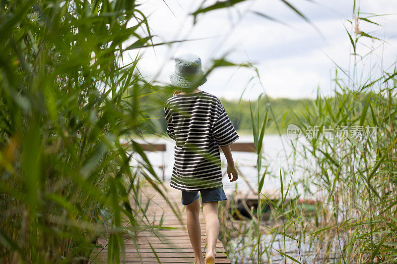 小男孩在湖边的码头上