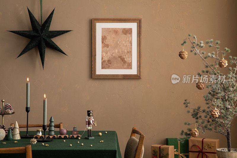 圣诞餐厅内部的美学构图，模拟海报框架，桌子，绿色桌布，烛台蜡烛，棕色墙壁，礼品，个人饰品。家居装饰。模板。