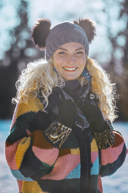 幸福的女人在冬天森林附近的白雪皑皑的草地