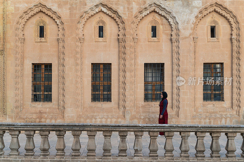 一名妇女走在历史名城马尔丁的石头豪宅的内露台上