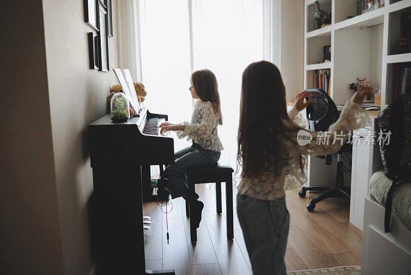 两姐妹一起愉快地练习钢琴