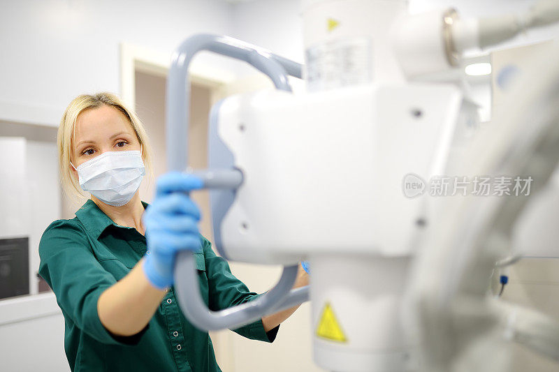 女技术员调整x光机。现代诊所的x光室里，女放射科医生要给病人拍x光片。