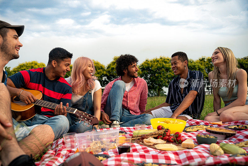 一群多民族青少年在公园户外野餐