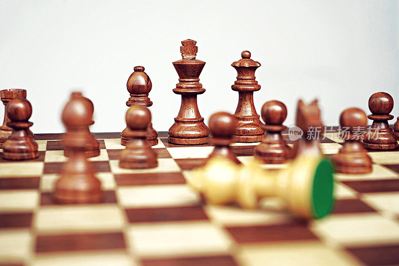 一幅水平的库存照片，描绘了一场国际象棋比赛中失败的情况，黑色棋子获胜，而白色棋子被击败