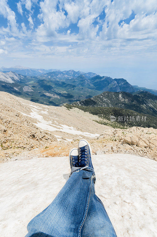 从冰峰俯瞰脚下的鞋子和山脉的POV(观点)照片