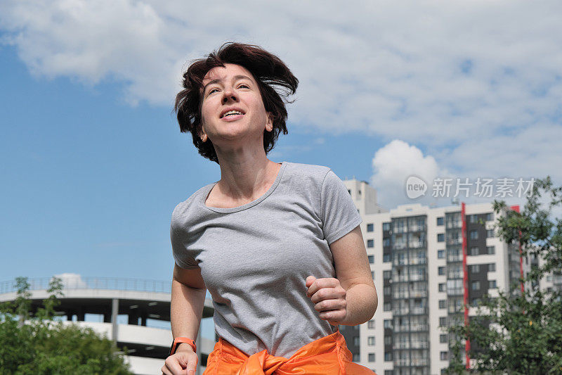 成熟的女人在城市邻里奔跑