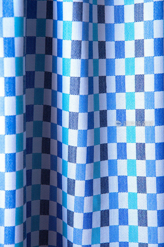 美丽的蓝色格子织物纹理与褶皱和对比鲜明的阴影。棉质的褶皱背景，纹理