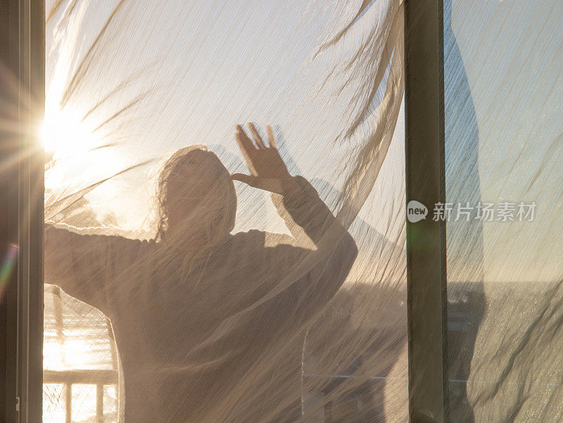 日出时，一名女子在阳台上放松