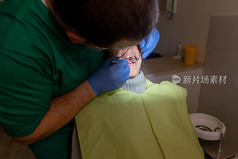 专门的男性牙医检查女性病人的嘴，在每月控制