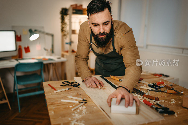 男艺术家在艺术工作室用砂纸打磨木头