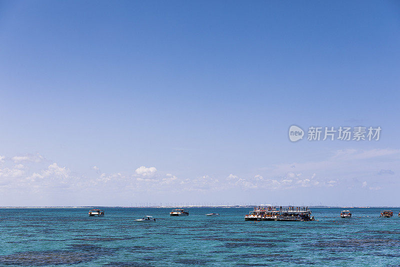 船只停泊在碧绿海水中的珊瑚上