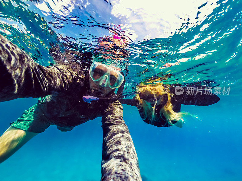 男人和女人一起在热带海洋下浮潜，在一张有趣的自拍中