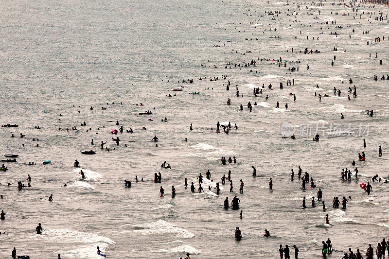 意大利炎热的夏日，在海上沐浴的人群剪影