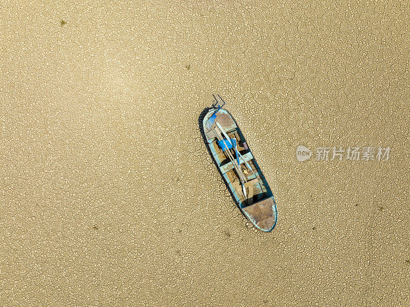 一艘渔船在干涸的湖床上的鸟瞰图。